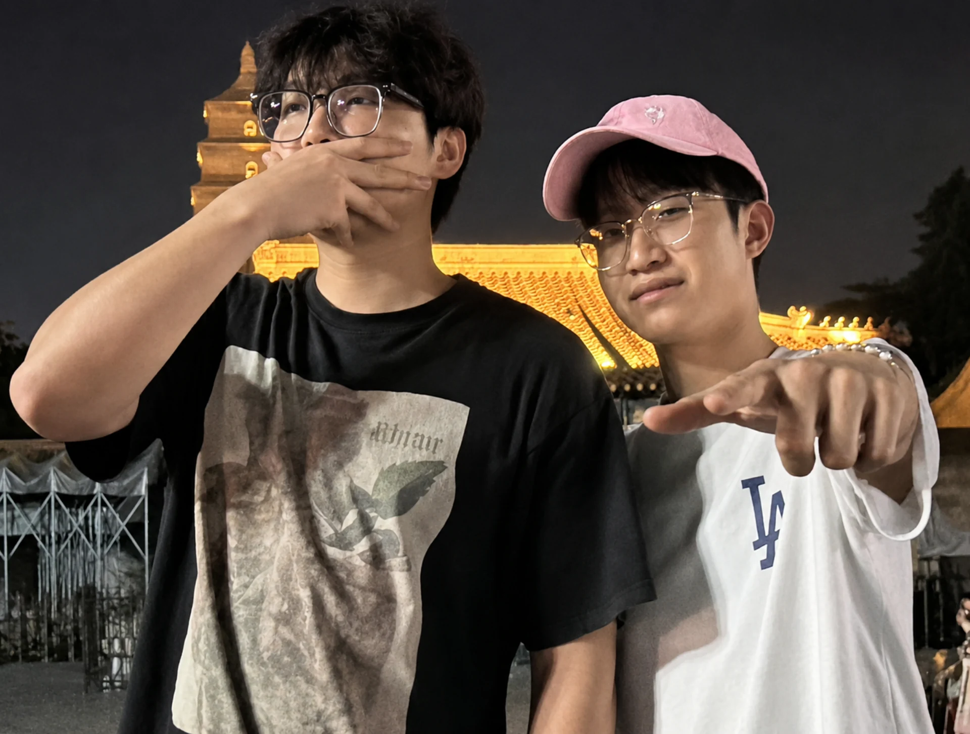 夜晚古建筑前，两位朋友一起合影
